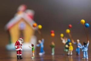 Miniature Santa Claus and children holding balloons, Merry Christmas and Happy New Year concept photo