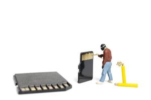 Miniature technician fixing pile SD cards on a white background photo