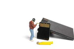 Miniature technician fixing pile SD cards on a white background photo