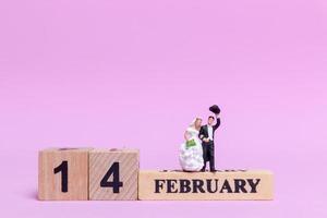 Miniature bride and groom on a pink background, Valentine's Day and wedding concept photo