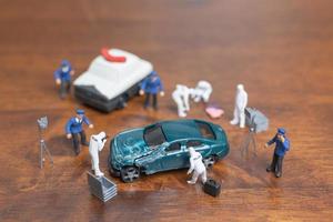 Miniature police and detective standing around a car, crime scene investigation concept photo