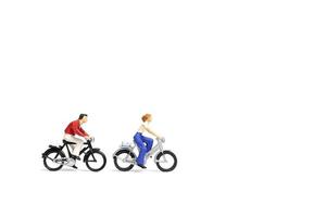 Miniature couple riding bicycles on a white background, Valentine's Day concept photo