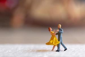 Pareja en miniatura bailando en un piso, concepto de día de San Valentín foto