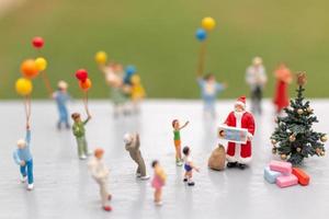 Miniature Santa Claus holding gifts for a happy family, Christmas and Happy New Year concept photo