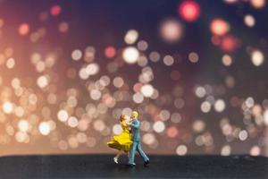 Pareja en miniatura bailando con un fondo bokeh, concepto de día de San Valentín foto