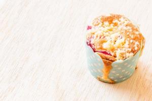 Blueberry muffins in a paper cupcake on a wooden background photo