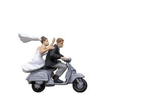 Miniature couple riding a motorcycle on isolated on a white background photo