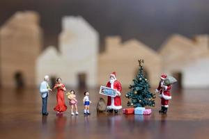 Papá Noel en miniatura y una familia feliz, feliz navidad y feliz año nuevo concepto foto