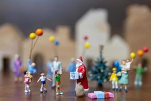 Papá Noel en miniatura y una familia feliz, feliz navidad y feliz año nuevo concepto foto