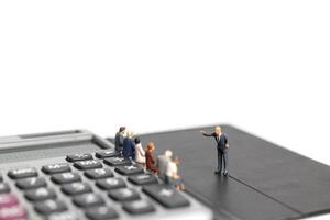 Miniature businessmen meeting on a calculator isolated on a white background, business and finance concept photo