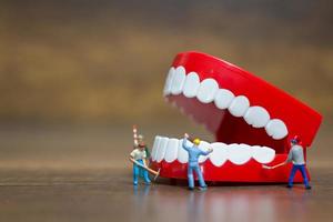 Miniature workers repairing a tooth, healthcare and medical concept photo