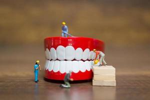 Miniature workers repairing a tooth, healthcare and medical concept photo