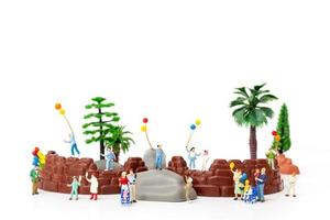 Familia en miniatura sosteniendo globos en el parque, concepto del día mundial del niño foto