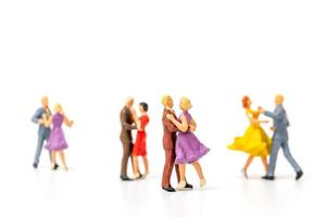 Gente en miniatura bailando sobre fondo blanco, concepto de día de San Valentín foto