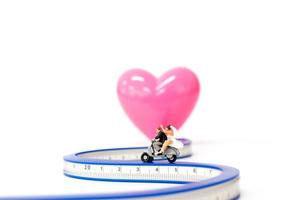 Pareja en miniatura enamorada en moto, concepto de día de San Valentín foto