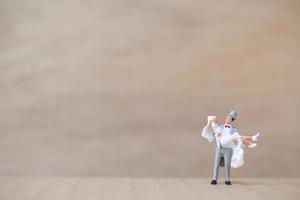 Miniature bride and groom on a wooden background photo