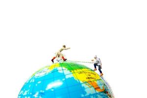 Miniature hikers climbing up on the globe, sport and leisure concept photo