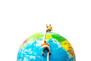 Miniature hikers climbing up on the globe, sport and leisure concept photo