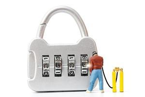 Miniature person working on a combination lock photo