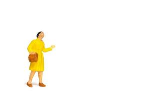 Miniature traveler holding a handbag standing on a white background, travel concept photo