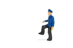 Miniature policeman standing isolated on a white background photo