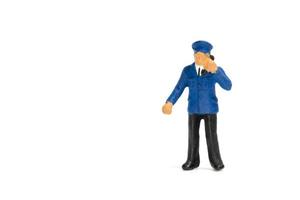 Miniature policeman standing isolated on a white background photo