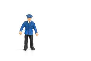 Miniature policeman standing isolated on a white background photo