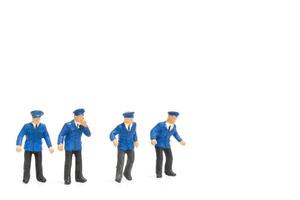 Miniature policemen standing isolated on a white background photo