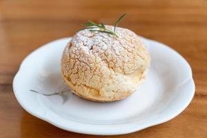 Choux cream placed on a white plate on a wooden background photo