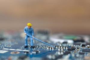 Persona en miniatura que trabaja en una placa de CPU, concepto de tecnología foto