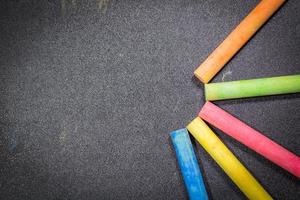 Row of rainbow colored chalk on a blackboard photo