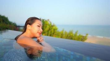 Young asian woman around outdoor swimming pool near sea beach video