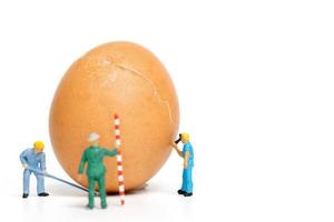 Miniature people working on Easter-eggs for Easter photo