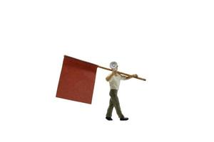 Persona en miniatura sosteniendo un megáfono con una bandera aislado sobre un fondo blanco. foto