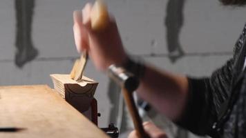 wood carver carves a wooden stand with a chisel video