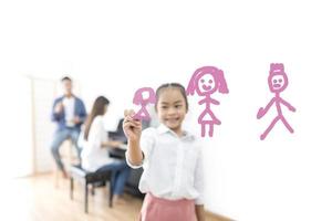 Girl drawing with parents in background photo