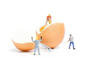 Miniature people working on Easter-eggs for Easter photo