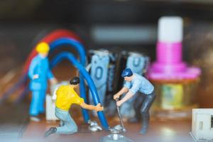 Trabajadores en miniatura que se unen para reparar circuitos electrónicos, concepto de trabajadores de la construcción foto