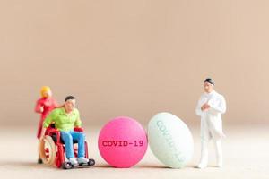 Miniature doctor researching and developing a Coronavirus vaccine, medicine to stop the COVID-19 outbreak concept photo
