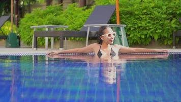 jovem mulher asiática perto da piscina no resort video