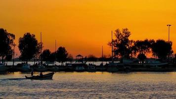 barca che entra nel molo al tramonto video