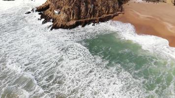 Waves washing over sand and cliffs beach, Albufeira, Algarve, Portugal video