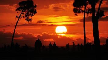 puesta de sol y siluetas de personas. video