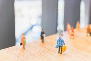 Miniature travelers walking on a wooden floor, holiday and travel concept photo