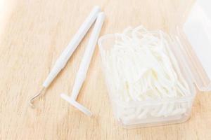 A box of white dental floss on a wooden background photo