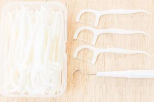 A box of white dental floss on a wooden background photo