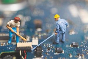 Equipo de ingenieros en miniatura que reparan una computadora portátil con teclado, concepto de reparación de computadoras foto