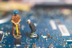 Miniature team of engineers repairing a keyboard computer laptop, computer repair concept photo