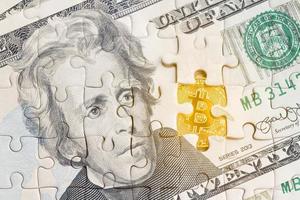 Billete estadounidense con un patrón de rompecabezas con un símbolo de bitcoin dorado foto