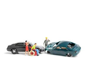 Miniature people at the scene of a car accident, car crash on a white background, drive safely concept photo